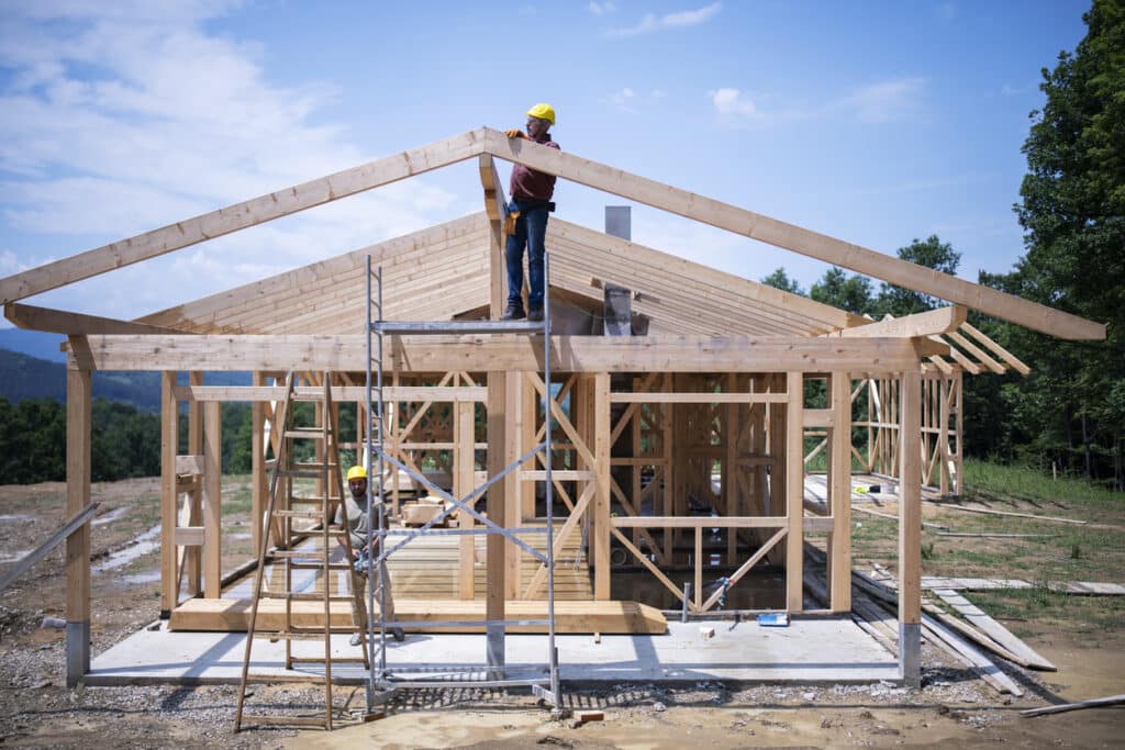 Two construction workers working on a house