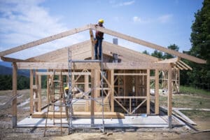 Two construction workers working on a house