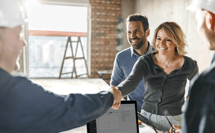 A residential builder meets with clients on the job site