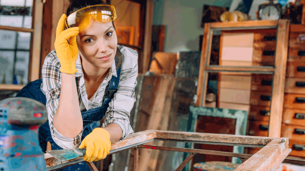 A carpenter looks into the camera for a photo of her work site.