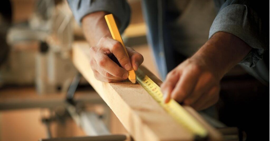 A builder measuring construction materials.