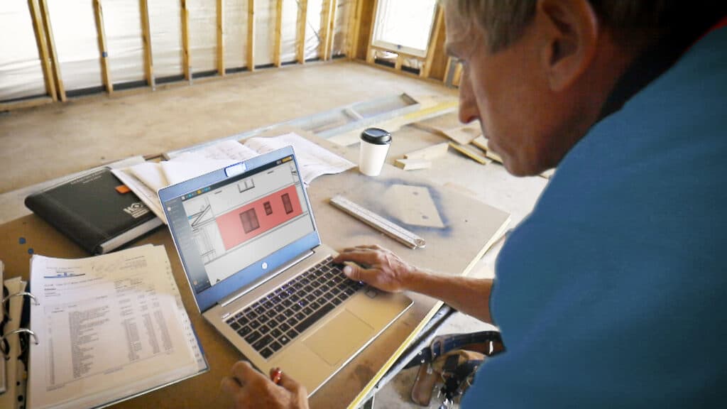 A builder using the Buildxact platform on a laptop.